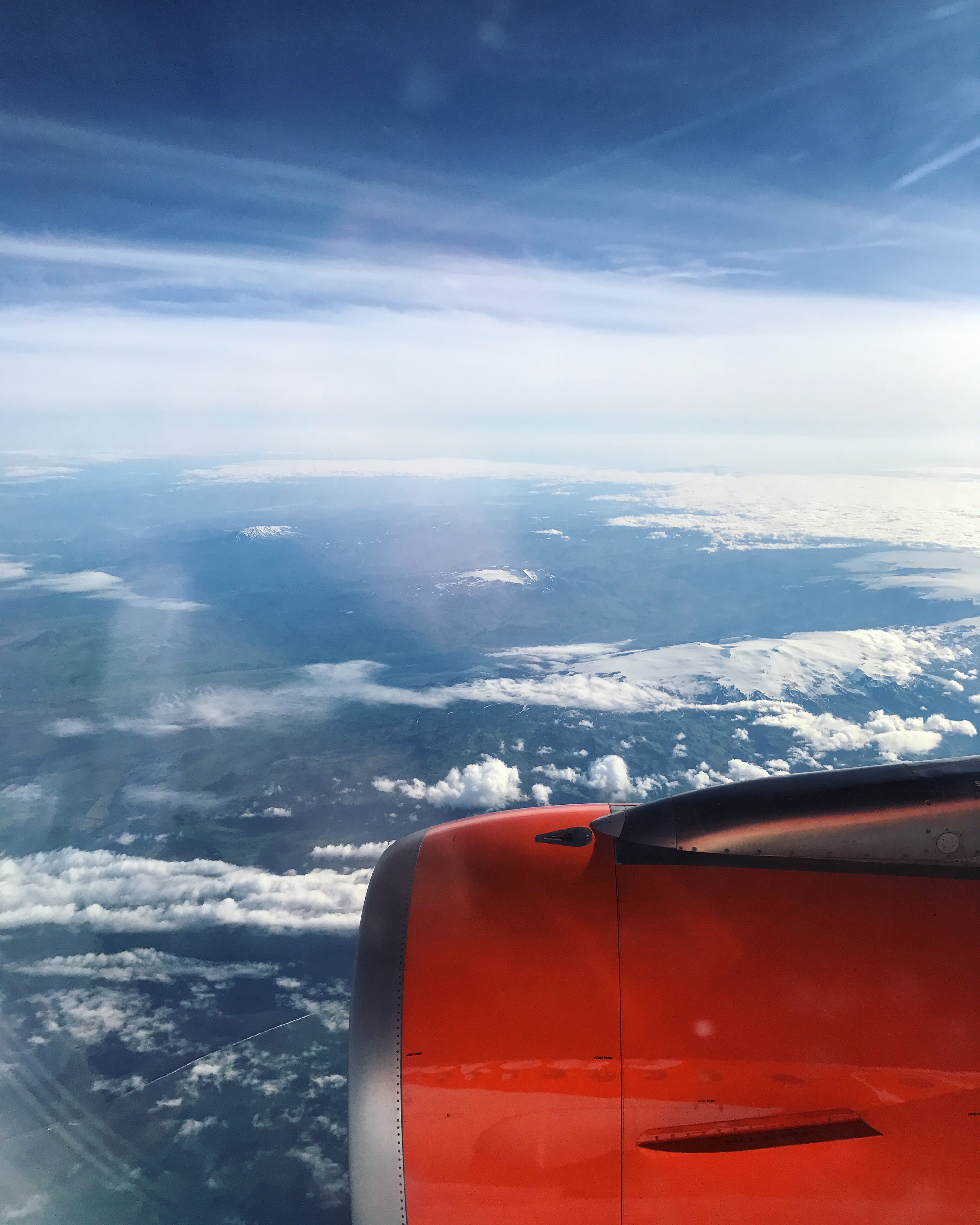 A blue sky, with clouds and an aeroplane wing